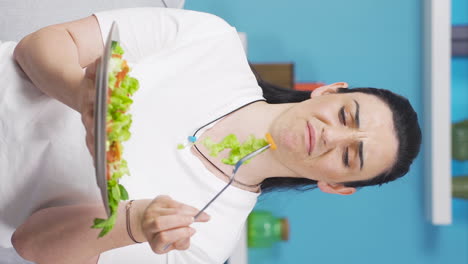 Vertical-video-of-Person-looking-at-vegetable-on-fork-with-unhappy-expression.-Difficulty-dieting.